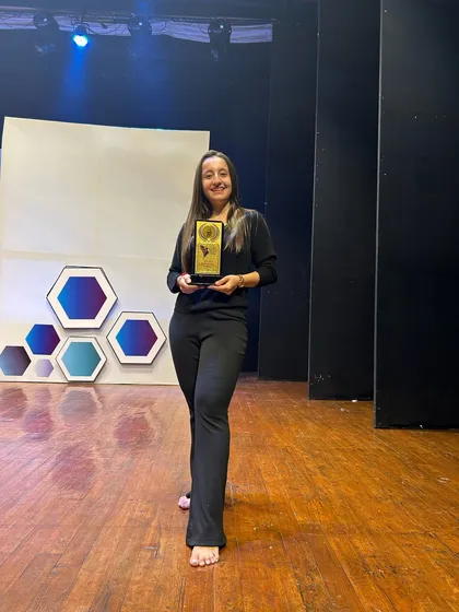 Proudly holding my Choreographer Achievement Award from Choreofeast on stage. This award represents my dedication to the art of dance.