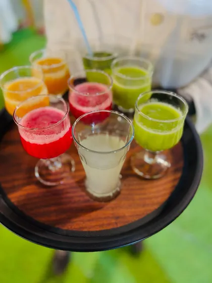 A close-up of the vibrant fresh juices, including watermelon, orange, and a green vegetable blend.