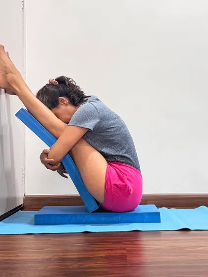 This supported Paschimottanasana uses foam blocks to create a deep, passive forward bend. The props allow the spine to lengthen and the mind to quiet, illustrating how we can use external support to facilitate an internal journey.