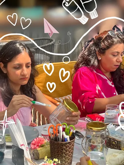 Here are some participants deeply engaged in decorating their memory jars during a group workshop. It's a wonderful sight to see friends sitting together, focused on creating something meaningful and enjoying the process.