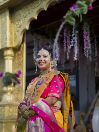The bride stands proudly in front of the ornate wedding venue entrance, her happiness shining through.