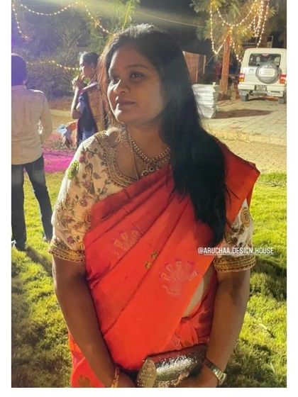 A client looking elegant in a contrast white floral blouse paired with a bright red saree. The blouse is finished with a delicate zardosi border along the neckline.