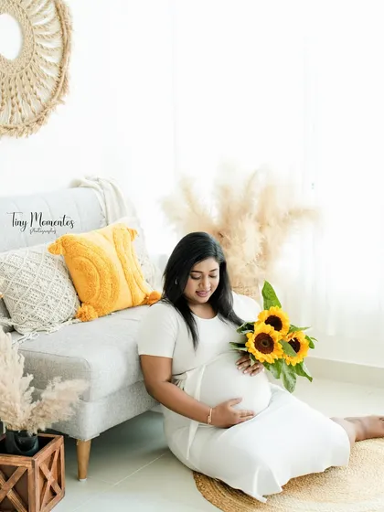 A sweet moment on the floor, holding a bouquet of sunflowers. This pose is relaxed, informal, and full of charm.