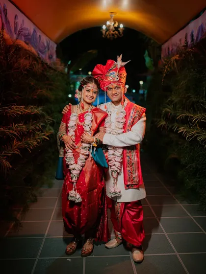 A full-length formal portrait of the couple, showcasing their stunning wedding outfits.