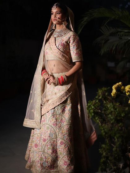A professional shot of a bride in one of my pastel floral lehengas, looking absolutely ethereal.