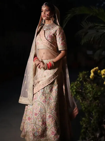 A professional shot of a bride in one of my pastel floral lehengas, looking absolutely ethereal.