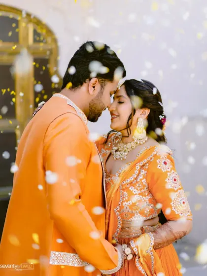 A couple shares a romantic moment amidst a shower of petals during their Haldi ceremony at the beautiful Alila Bishangarh.