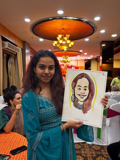 A guest at a wedding proudly holds up her finished caricature, a colorful and fun portrait to remember the night.