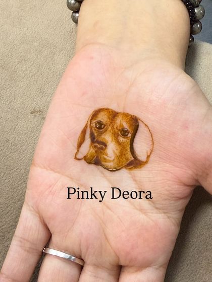 A simple, minimalist portrait of a dog's face on the palm. Even without much background, its soulful eyes are full of expression.