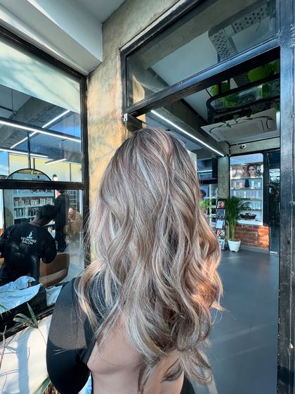 A beautiful lived-in ash blonde, perfect for the winter season. The cool tones and soft waves create an elegant and stylish look.