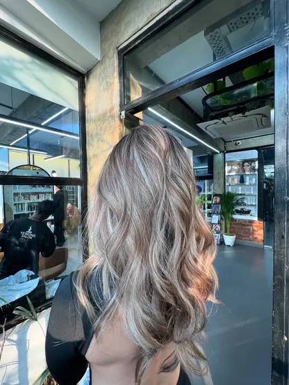 A beautiful lived-in ash blonde, perfect for the winter season. The cool tones and soft waves create an elegant and stylish look.
