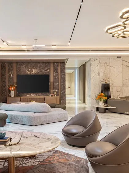 This finished living space showcases our expertise in creating interiors that are both luxurious and livable. We layered rich textures, custom furniture, and statement lighting over polished marble floors to achieve a sophisticated yet comfortable environment.