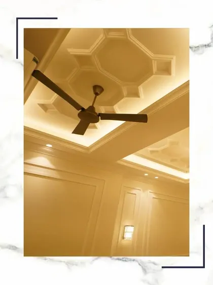 A view looking up at one of our geometric false ceiling designs. The recessed cove lighting provides a soft, ambient glow, highlighting the architectural detail and making the room feel even more spacious.
