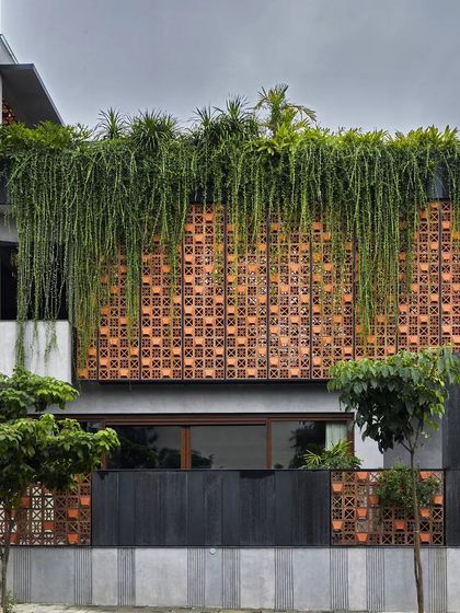 The terracotta screen at Project 58 is topped with a planter, from which vines hang down, creating a living facade that changes with the seasons.
