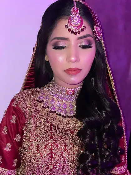 A close-up under purple lighting. This shows how the glittery eye makeup catches the light, creating a dramatic and glamorous effect.