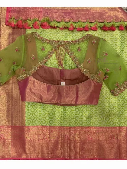 The back of this pink and green blouse features a triangular keyhole cutout, with the sheer green net sleeves adding to the delicate look.