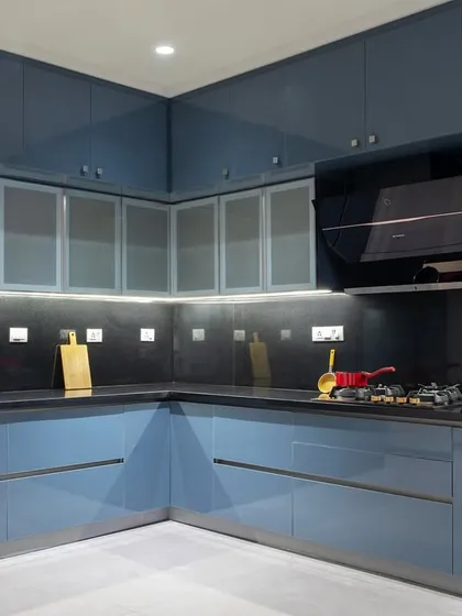 A wider view of the U-shaped kitchen, showcasing the ample counter space and smart layout. The mix of solid and frosted glass cabinet doors adds visual variety.