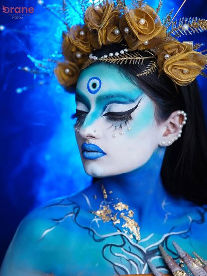 A serene yet powerful portrait, this image showcases the beautiful blending of colors and the intricate details of the makeup.