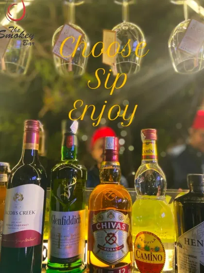 Choose, Sip, Enjoy. This image showcases a selection of premium spirits available at one of my bars, with elegant glassware hanging above, ready to be filled.