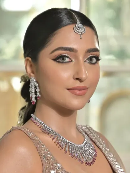 A close-up on the model's face, with the hair pulled back cleanly to highlight the maang tikka and earrings. This is essential for beauty and jewellery campaign shoots.