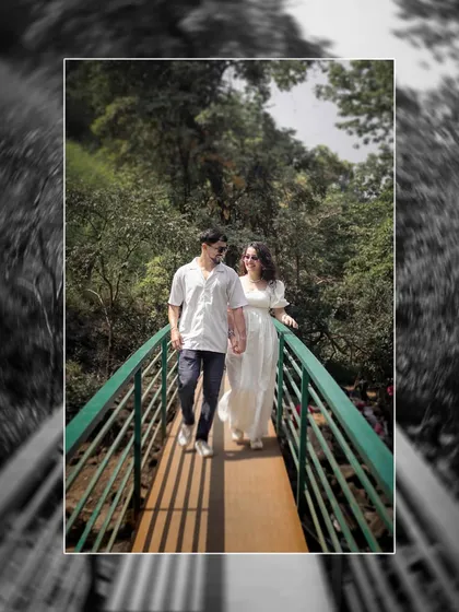 A playful walk across a bridge surrounded by lush greenery, capturing a fun and candid moment during an adventure shoot.