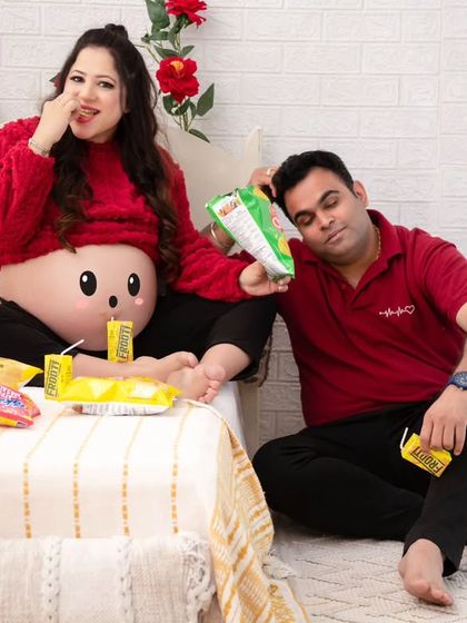 The aftermath of the snack party. This funny and relatable portrait captures the couple in a moment of playful exhaustion, surrounded by their favorite treats.