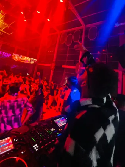 From my perspective at the DJ booth, watching the dance floor erupt under the red and blue lights. This is what a successful club night looks like.