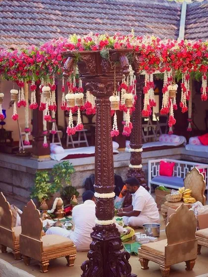 I have a special love for heritage venues. Here, we designed a traditional mandap with antique wooden pillars and vibrant bougainvillea, perfectly complementing the timeless charm of a 240-year-old Thottimane.