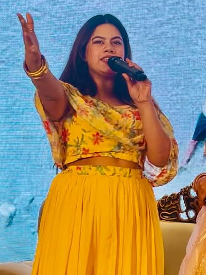 Hyping up the crowd during an engagement ceremony. My hand is raised to get everyone to cheer for the couple.