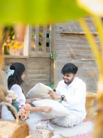 A fun and candid moment of a couple having a pillow fight during their casual setup at a studio. It shows that even in a studio, we can capture lighthearted and personal moments.