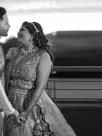 A black and white shot that highlights the couple's happy expressions and the beautiful textures of their outfits.