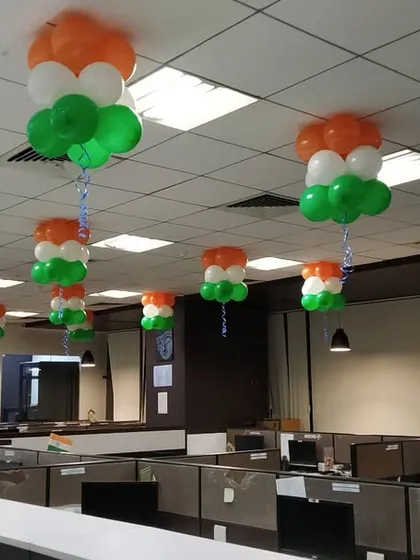 A wide view of an office space decorated with hanging tricolor balloon arrangements. We can scale our decorations to cover large floors and multiple cubicle sections.
