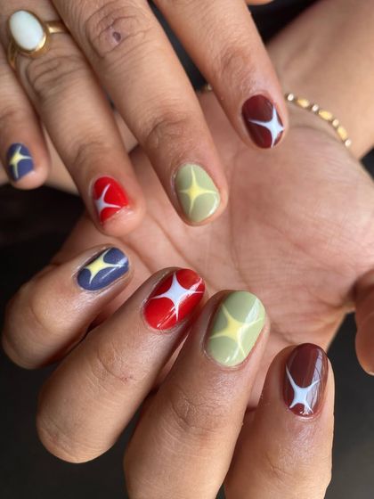 Both hands, showing off the full playful set. Each nail is a little different, creating a cohesive but unique look that’s full of personality.