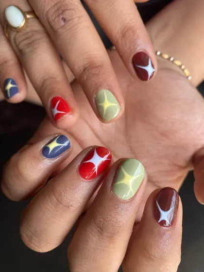 Both hands, showing off the full playful set. Each nail is a little different, creating a cohesive but unique look that’s full of personality.