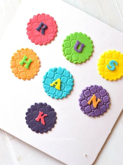 I also make custom fondant toppers for cupcakes. Here, I created colourful textured discs with the letters of a child's name to personalize a birthday cupcake set.