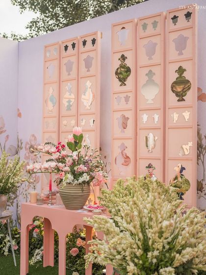 Custom-made screens with perfume bottle cutouts and mirror details serve as a unique and artistic backdrop.