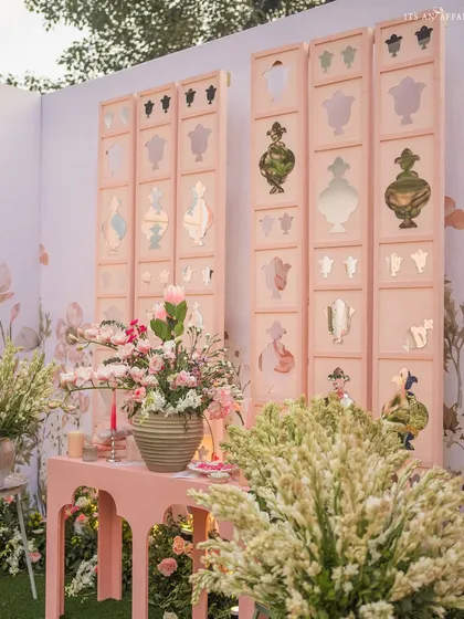 Custom-made screens with perfume bottle cutouts and mirror details serve as a unique and artistic backdrop.