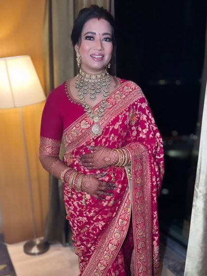 The full reception look. The rich red saree, heavy jewelry, and dramatic makeup come together to create a powerful and unforgettable bridal statement.