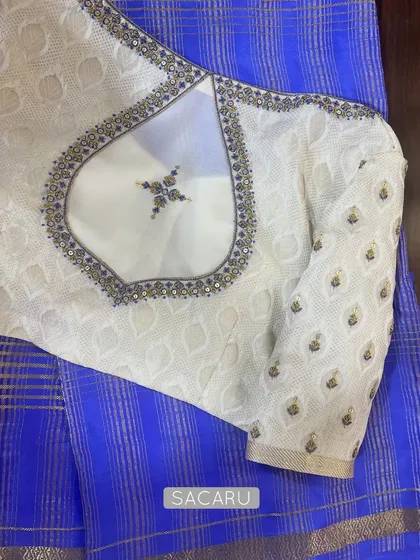 Contrasting a rare blue Mysore silk saree with an off-white embroidered georgette blouse, featuring a unique back cutout with a single motif.