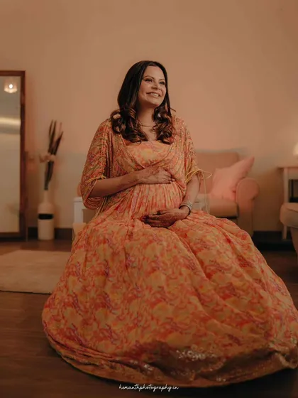 An indoor maternity photo capturing the expectant mother in the comfort of her home. The warm, soft lighting creates a cozy and intimate atmosphere.