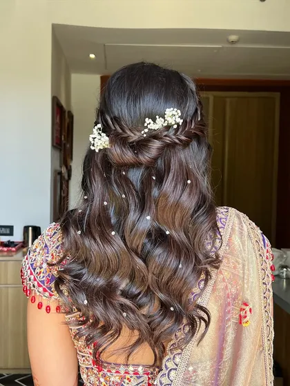 This hairstyle is all about soft, romantic beauty, with a simple braid and scattered pearls creating a dreamy effect.