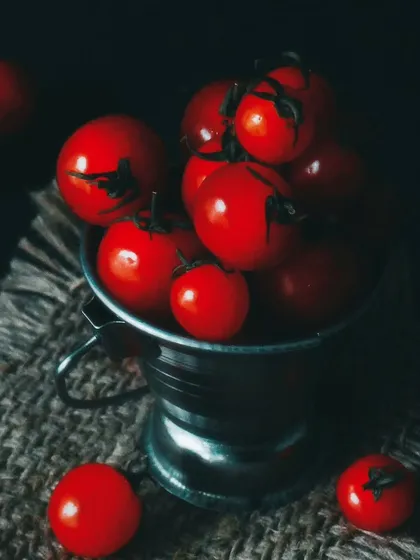 A darker, more dramatic version of the cherry tomatoes shot, using shadows to create a moody and artistic food photograph.