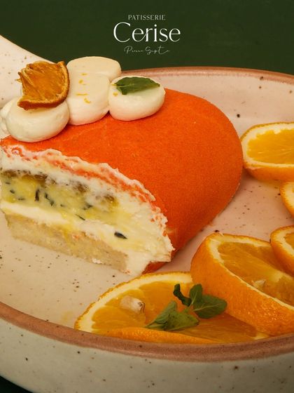 A slice of the Citrus Chill, an airy and charming entremet with a dance of orange, mint, and mascarpone mousse.