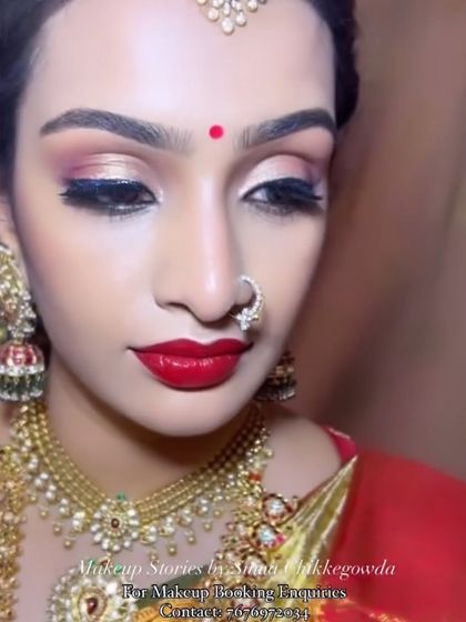 A close-up on the eye makeup and lips for a royal bridal look. The shimmery eyeshadow and perfectly defined winged liner, paired with a rich red lip, create a dramatic and unforgettable effect.