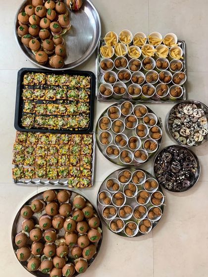 A spread of party favorites being prepared in my kitchen. I make everything in batches to ensure freshness, from mini burgers and fries to pizza crackers and cheese balls.