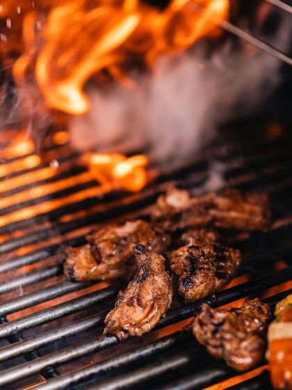 This action shot from our Mother's Day Cool Off Brunch shows meats sizzling on the grill. Our live cooking stations are a key feature of our special event dining experiences.
