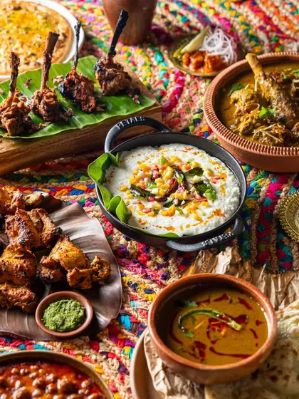 Food photography is about more than just the dish; it's about the entire table. This vibrant spread for Bawri India captures a feast of colors and textures, from the rich curries to the fresh garnishes, all set against a colorful backdrop to evoke a sense of celebration.