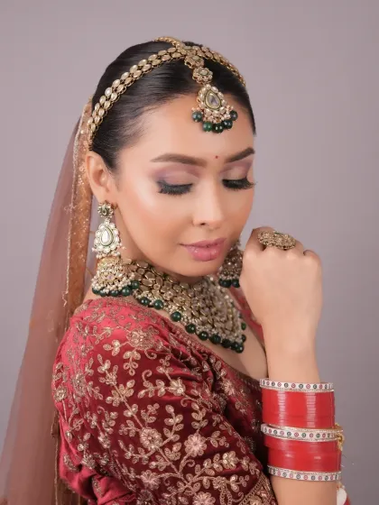 The complete traditional bridal look, including the chooda (bangles). My training ensures you understand the cultural significance and styling of different Indian bridal traditions.
