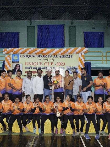 Our academy's team posing with their trophy and honored guests during the Unique Cup 2023 awards ceremony.