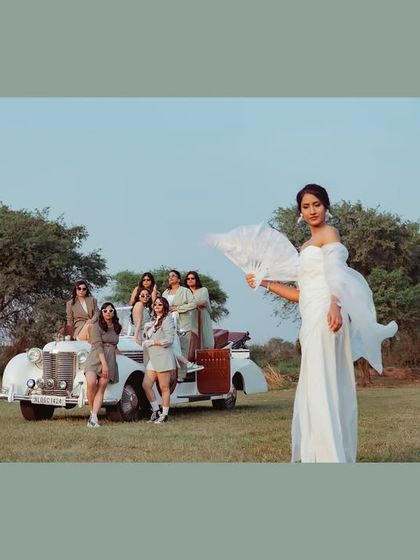 A bride and her bridesmaids, looking effortlessly chic. This stylish shot of Shristi and her squad with a vintage car is a modern, editorial take on the classic bridesmaid photo.
